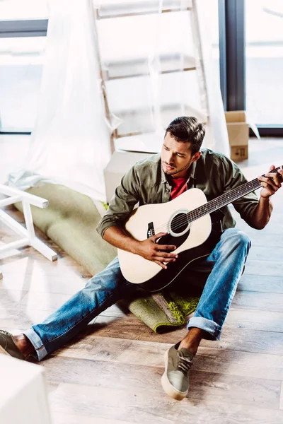 Man met de gitaar in de nieuwe woning — Stockfoto