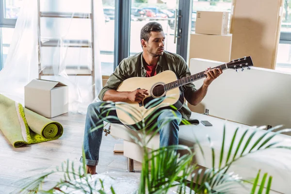 Pria dengan gitar di rumah baru — Foto Stok Gratis