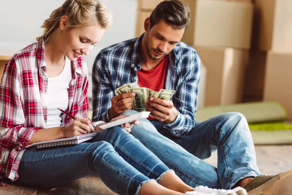 Pareja joven contando dinero — Foto de Stock