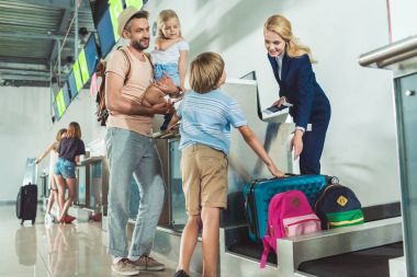 family at check in desk in airport clipart