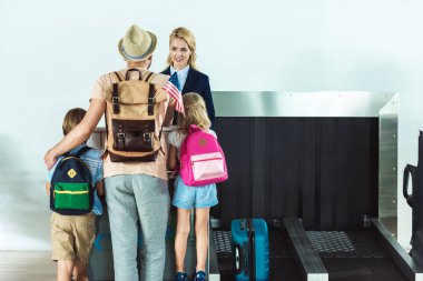 family at check in desk at airport clipart