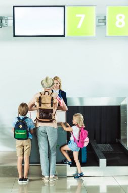family at check in desk at airport clipart