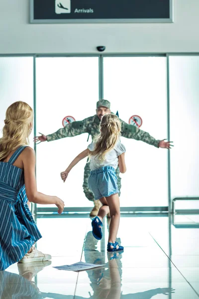 Happy child running to father in military uniform — Free Stock Photo