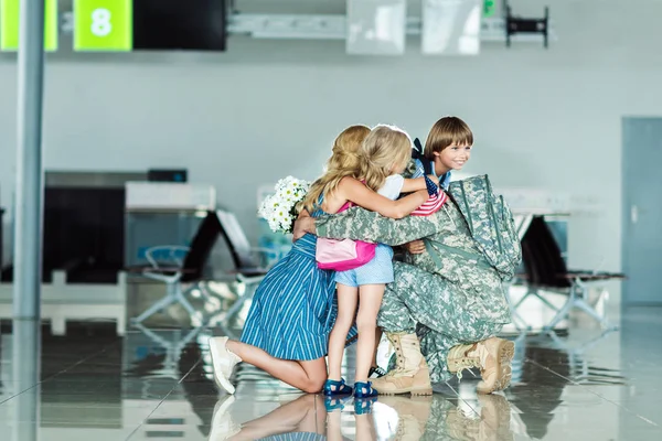 Family hugging father at airport — Stock Photo, Image