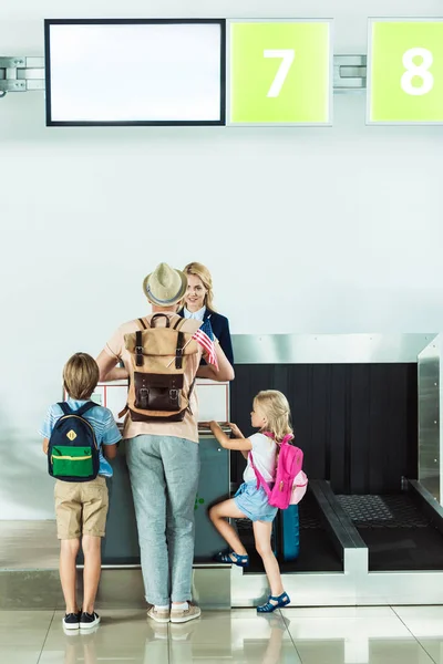 Familie bij check-in balie op de luchthaven — Stockfoto