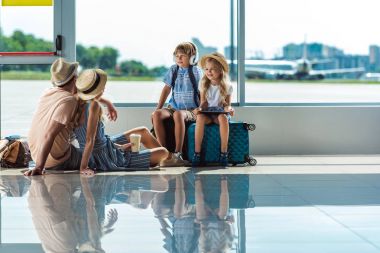 Ebeveynler ve çocuklar yatılı havaalanında bekliyor
