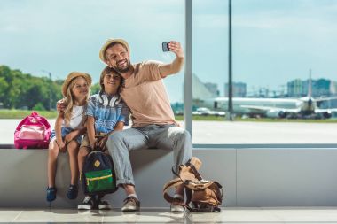 family taking selfie in airport clipart