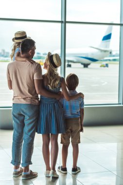 family looking out window in airport clipart