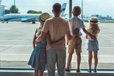 family looking out window in airport clipart