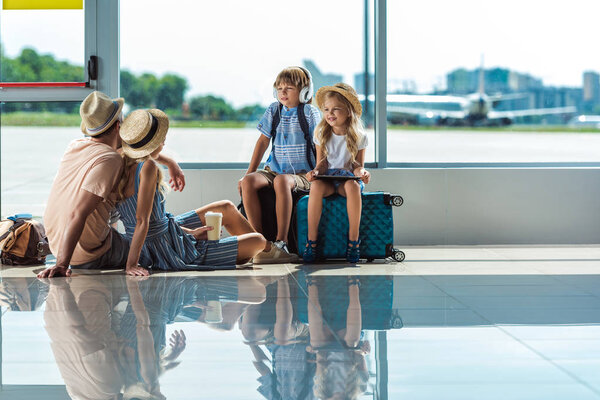 родители и дети в ожидании посадки в аэропорту
