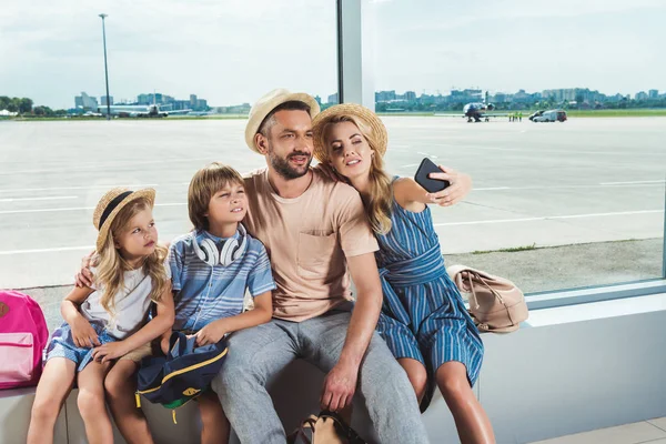 Gelukkige familie nemen selfie in luchthaven — Stockfoto