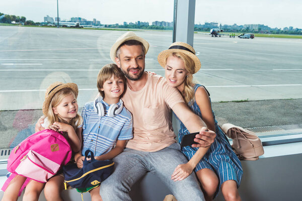 happy family taking selfie in airport