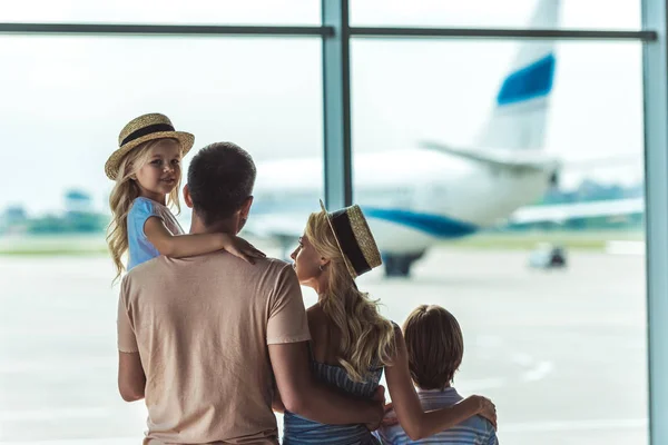 Familie kijkt uit raam in luchthaven — Stockfoto