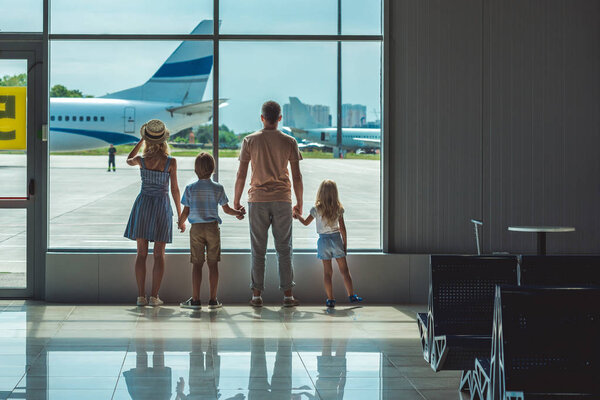 family looking out window in airport