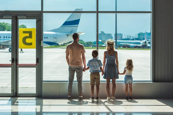 Família olhando para fora janela no aeroporto — Fotografia de Stock