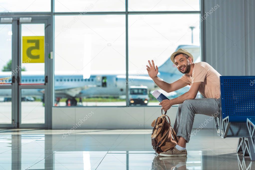 man waving to someone in airport