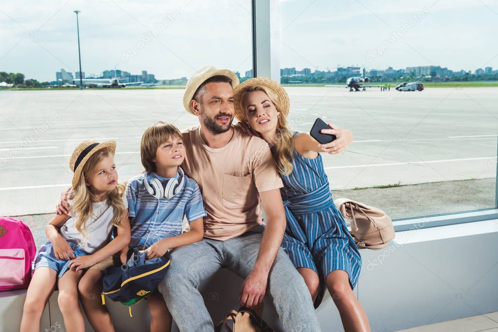 happy family taking selfie in airport