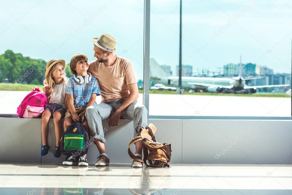 father and kids waiting for boarding