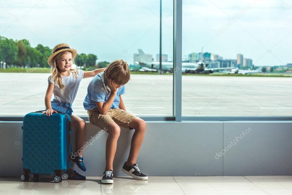 siblings waiting in airport