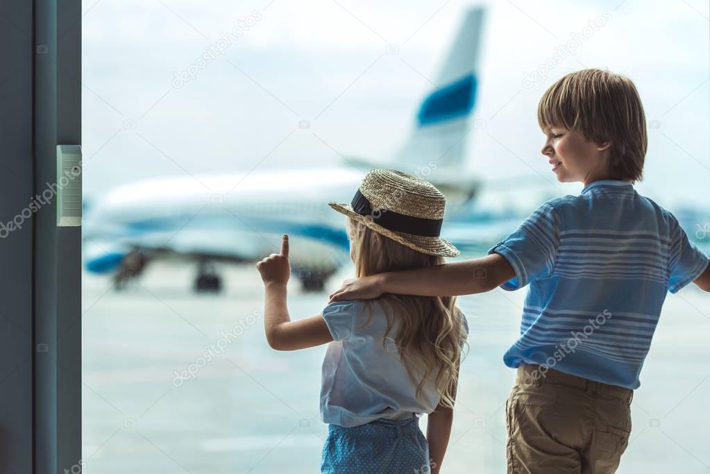 kids looking out window in airport