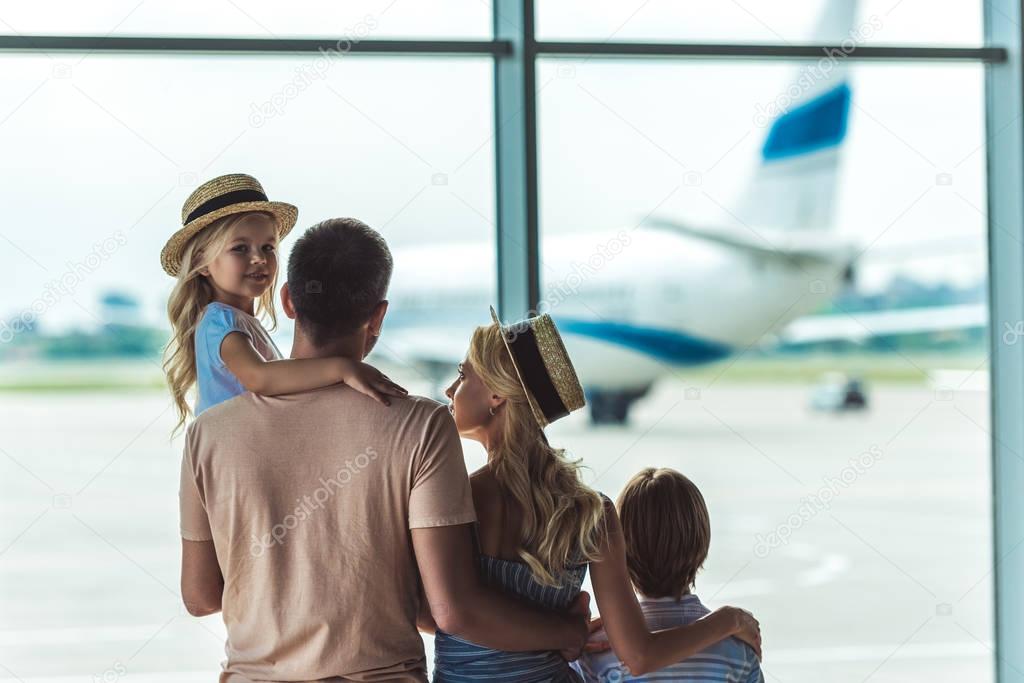 family looking out window in airport