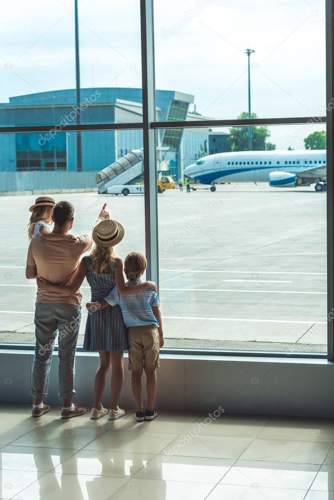 family looking out window in airport