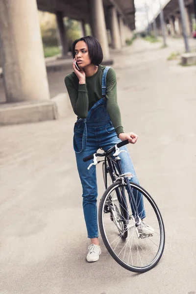 Woman on bicycle talking by phone — Free Stock Photo