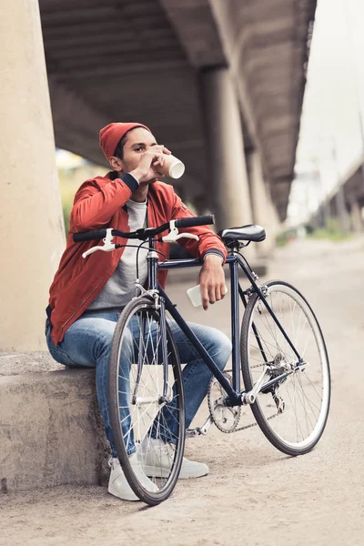Чоловік з велосипедом п'є каву, щоб піти — стокове фото