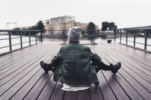 Žena sedí na dřevěném molu — Stock fotografie