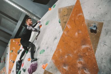 Man climbing wall with grips clipart