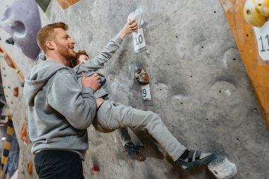 Dad teaching son how to climb clipart