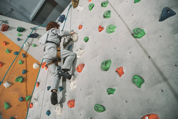 Parede de escalada menino de cabeça vermelha — Fotografia de Stock