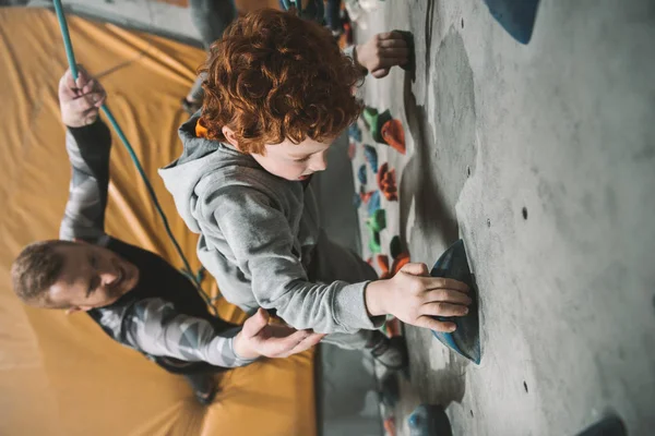 Little boy climbing wall at gym — Stock Photo, Image