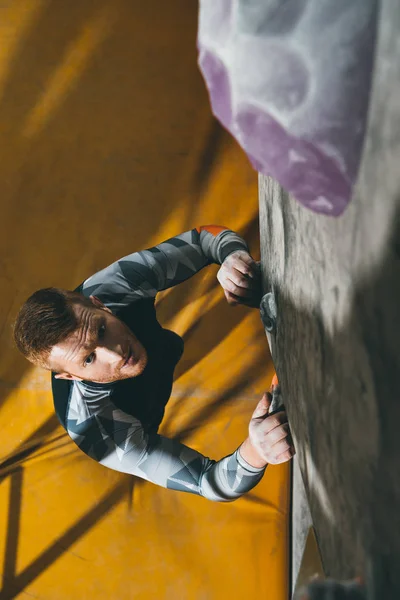 Man climbing wall with grips — Free Stock Photo