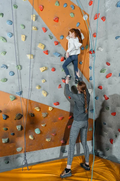 Petite fille mur d'escalade avec poignées — Photo