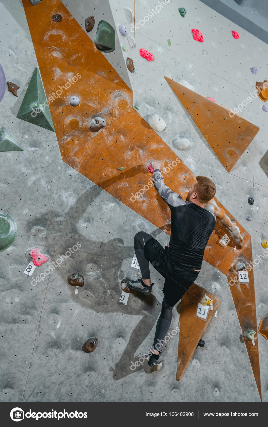 Man climbing wall with grips — Stock Photo © ArturVerkhovetskiy 166402908