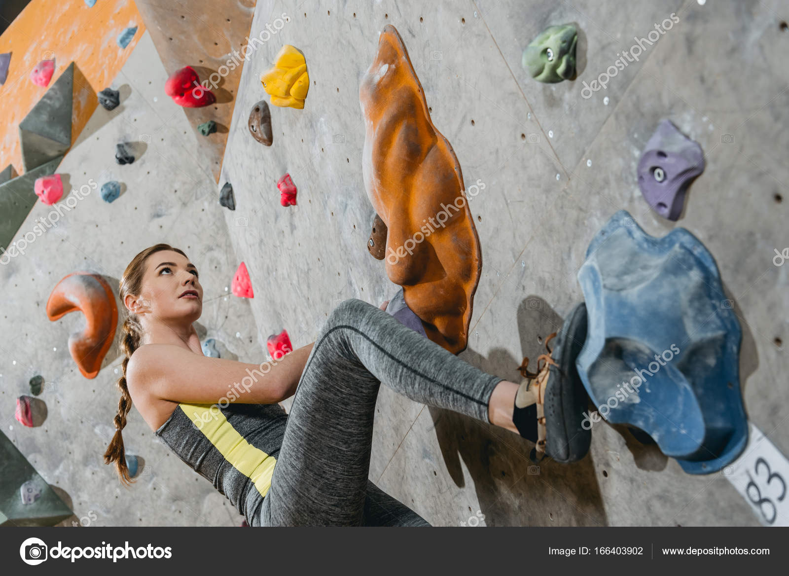 Woman climbing wall with grips — Stock Photo © ArturVerkhovetskiy