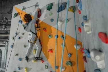 Little boy climbing wall with grips clipart