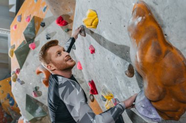 Man climbing wall with grips clipart