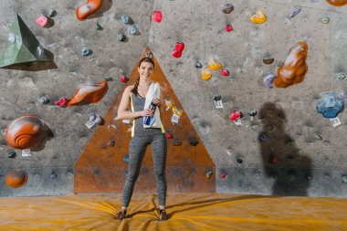 young woman in front of climbing wall clipart
