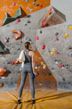 young woman in front of climbing wall clipart