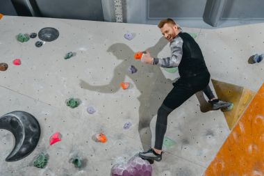 Man on climbing wall showing thumb-up clipart