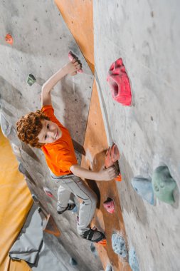 red-headed boy climbing wall clipart