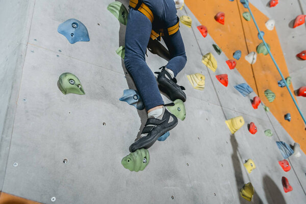 little boy climbing wall with grips