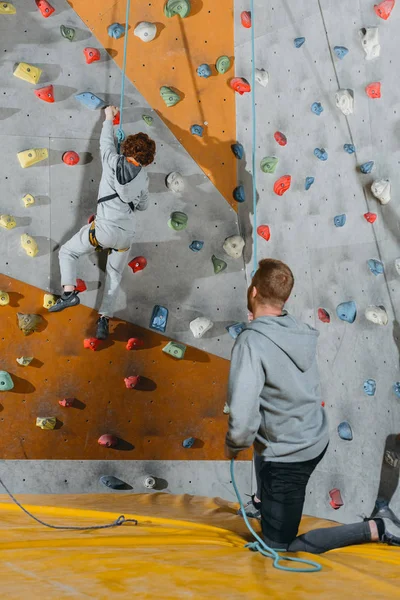 Ragazzino arrampicata parete con impugnature — Foto Stock