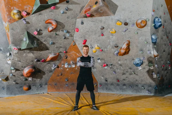 Young man in front of climbing wall — Free Stock Photo