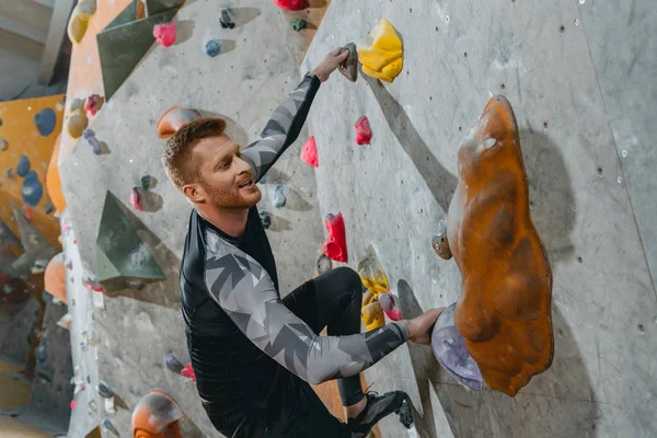 Man climbing wall with grips — Stock Photo, Image