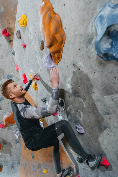 Man climbing wall with grips