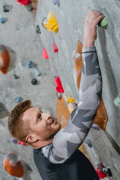 Hombre escalada pared con agarres — Foto de stock gratuita