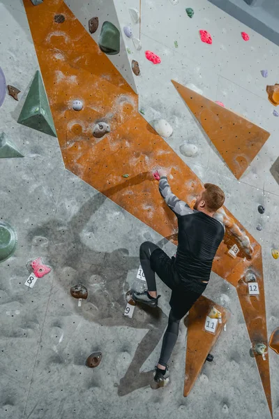 Duvara tutunarak tırmanan adam.